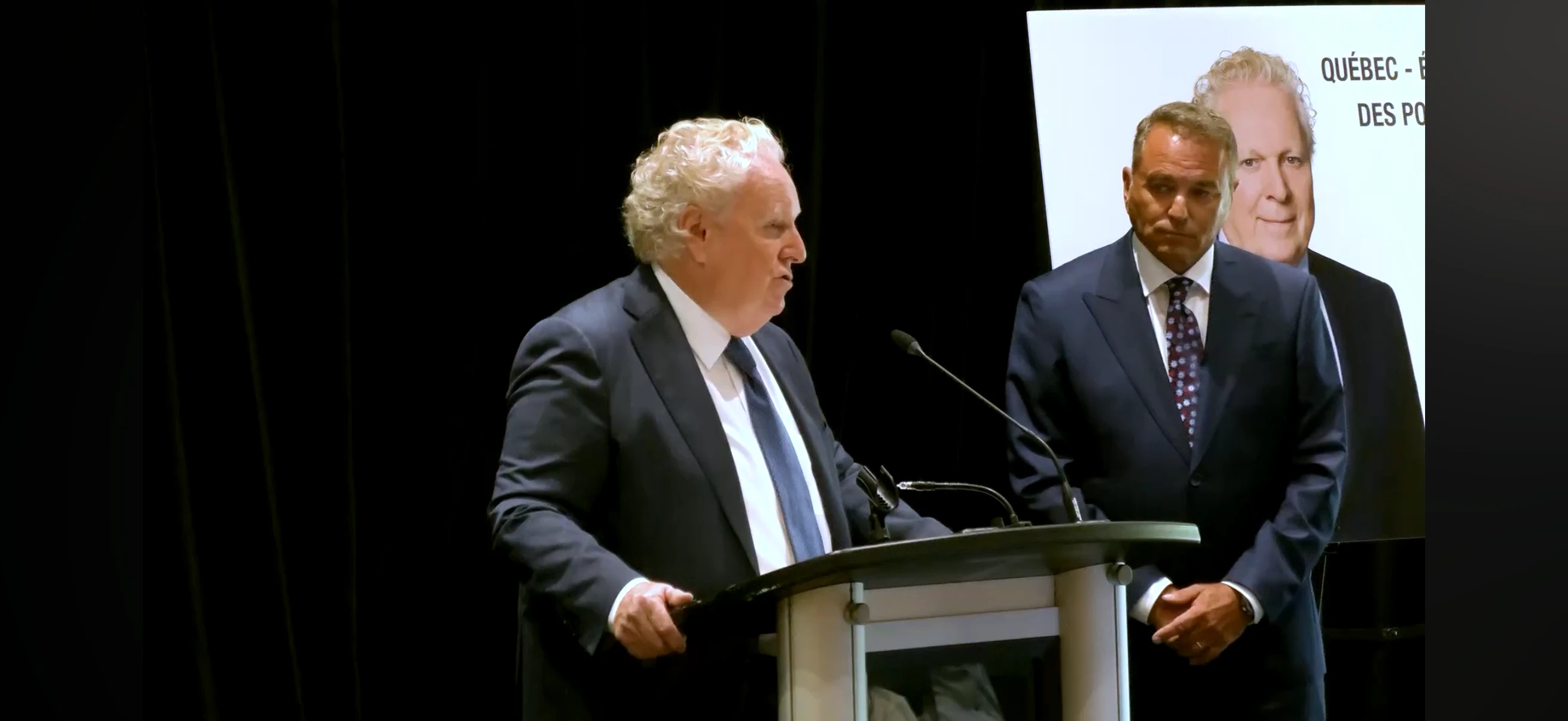 Jean Charest au podium — Pierre Jobin en arrière-plan